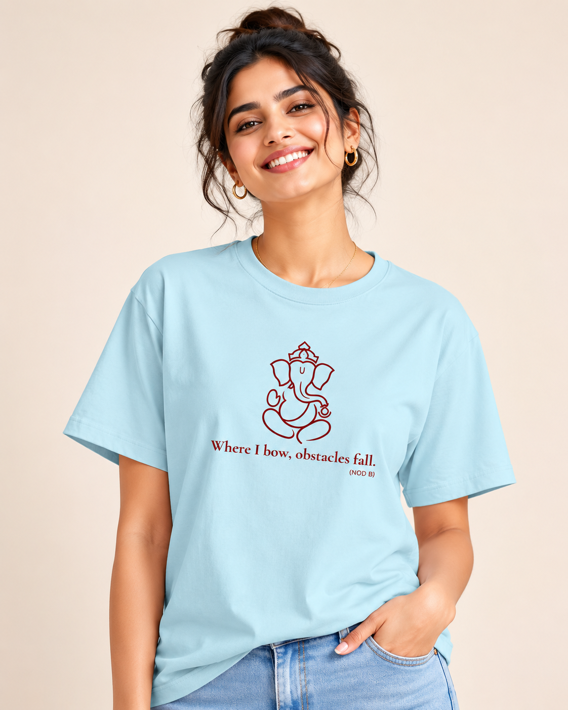 Woman modeling a baby blue unisex cotton t-shirt with a red Lord Ganapati design by Vedic Bridge.