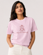 Woman modeling a light baby pink unisex cotton t-shirt with a red Lord Ganapati design by Vedic Bridge.